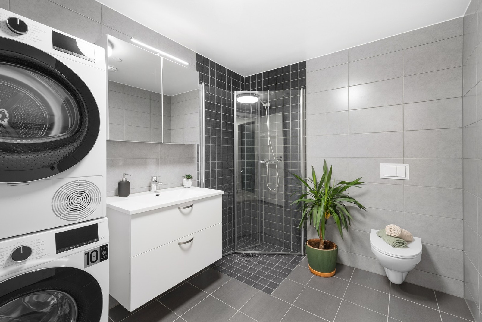 Stilrent og stort flislagt bad fra 2023 med vannbåren gulvvarme og opplegg for vaskemaskin og tørketrommel Galleribilde