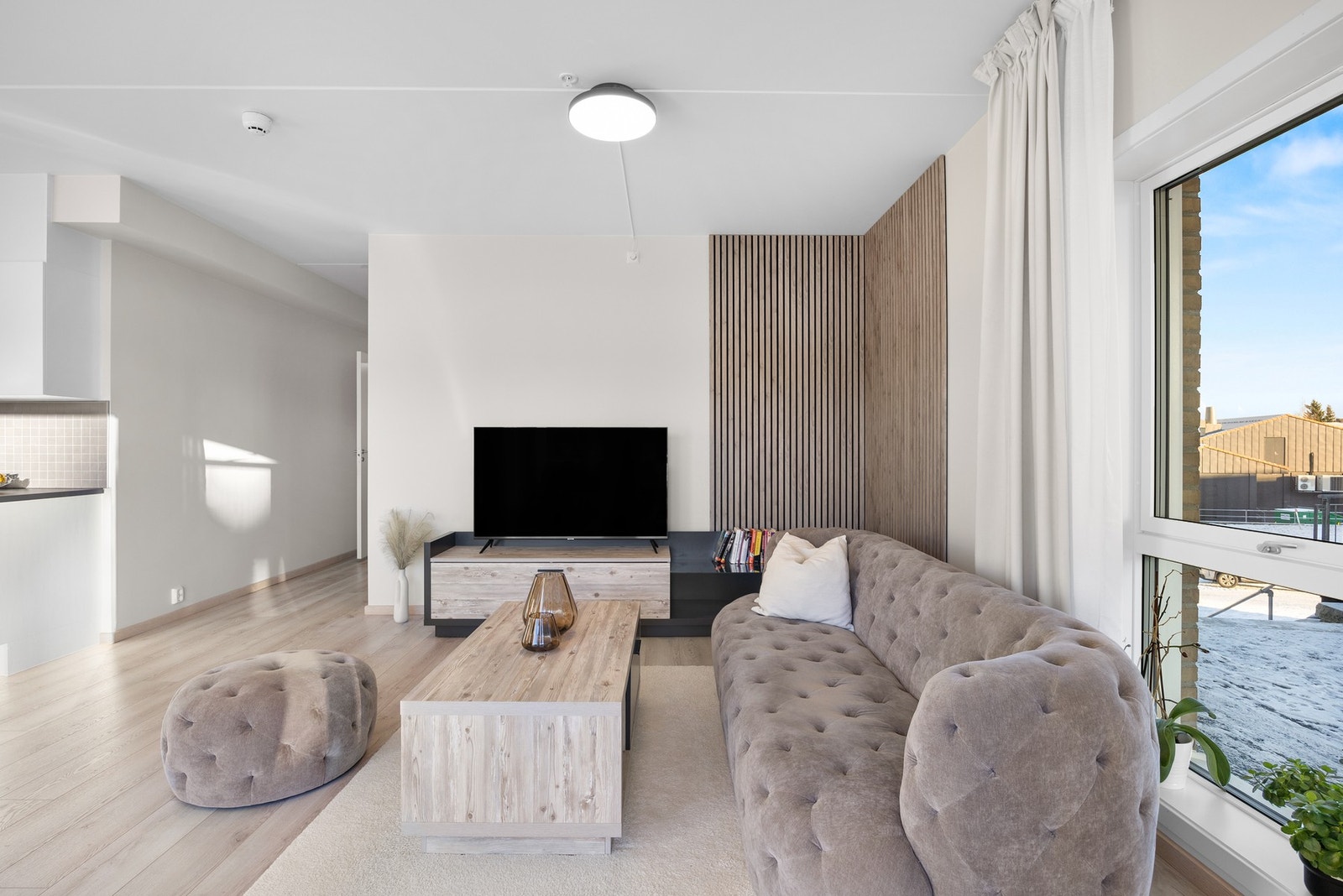 Kontrastvegg med stilige spiler i stuen, ellers glatte, malte flater og 1-stavs laminat i alle rom Galleribilde