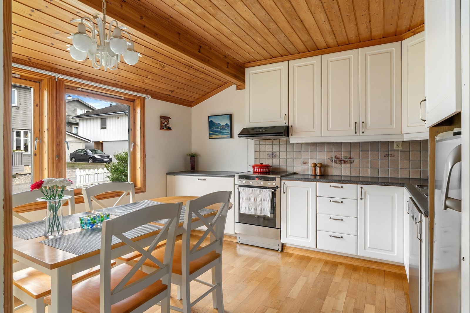 Romslig kjøkken med kjøkkeninnredning i hvit utførelse. Galleribilde