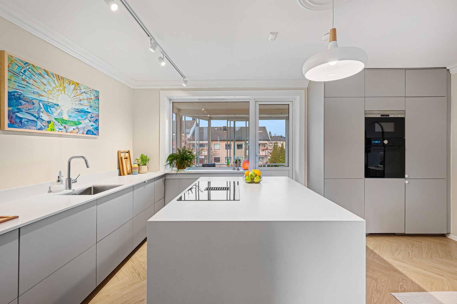 Stilrent kjøkken med moderne, slette fronter og en elegant kompositt benkeplate som gir et tidløst uttrykk. Galleribilde