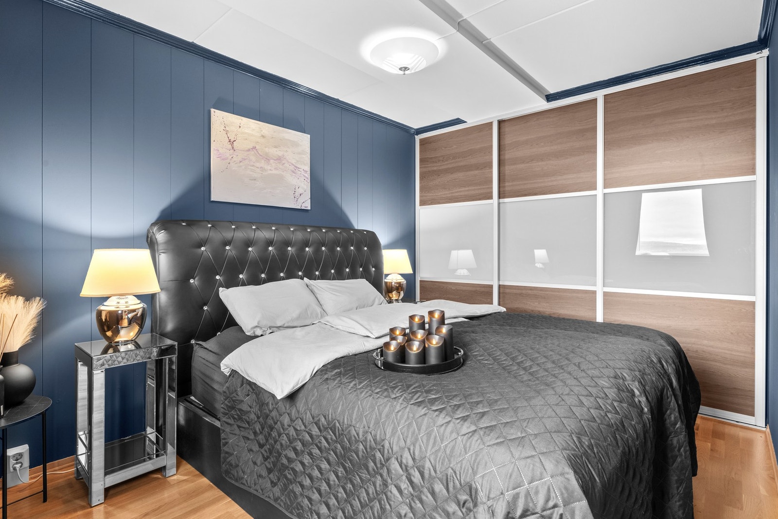 Stilfullt soverom med stor skyvedørsgarderobe som gir praktisk og romslig oppbevaring. Galleribilde