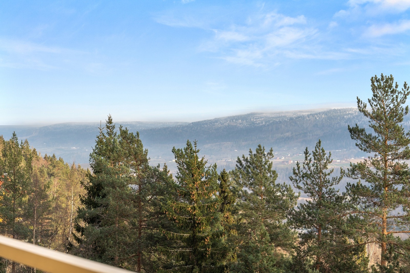 Nydelig utsyn mot skogkledde åser og kulturlandskap så langt øyet rekker. Galleribilde