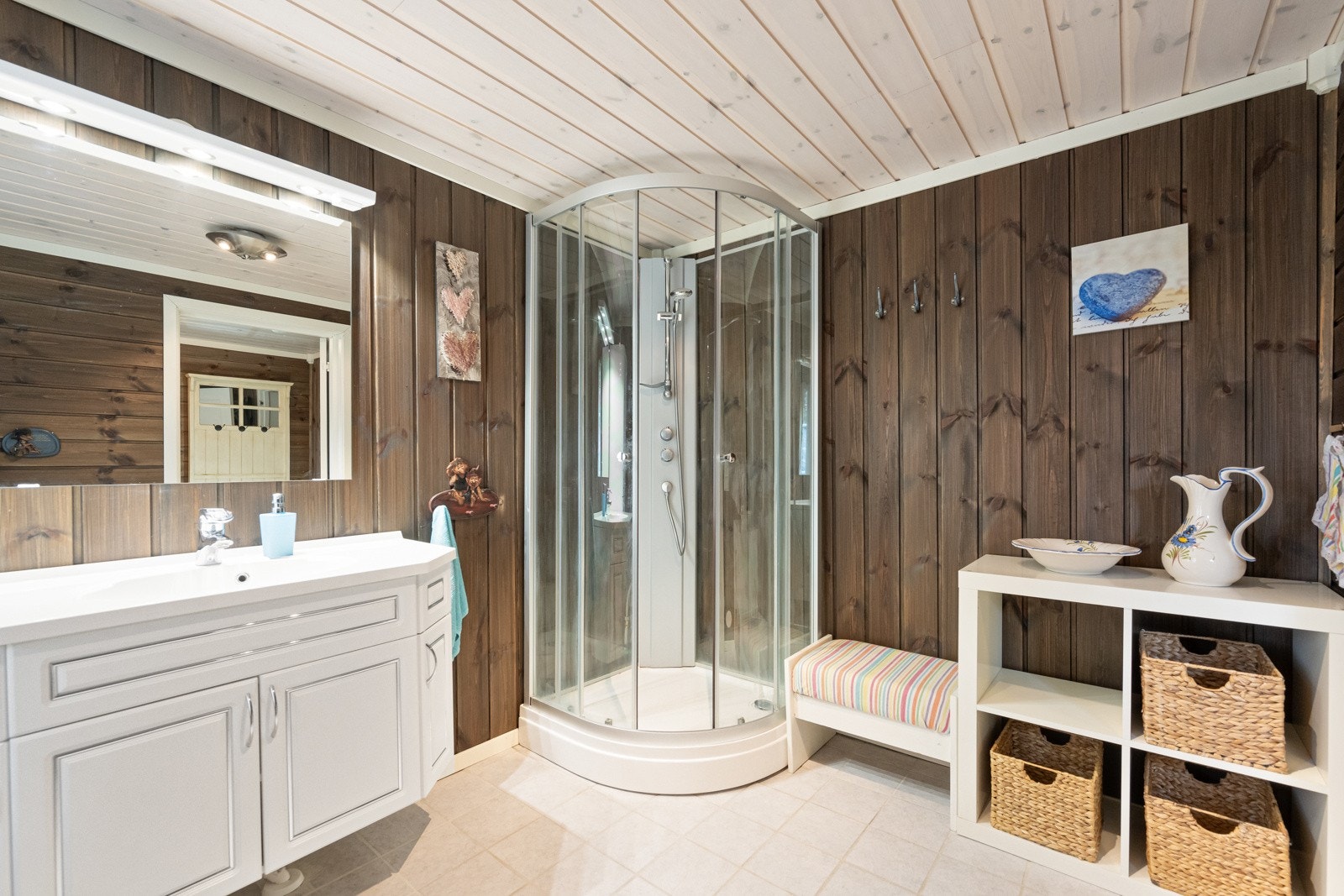 Badet er innredet med WC, servant med skap og dusjkabinett. Rommet varmes opp med varmekabler i gulv Galleribilde