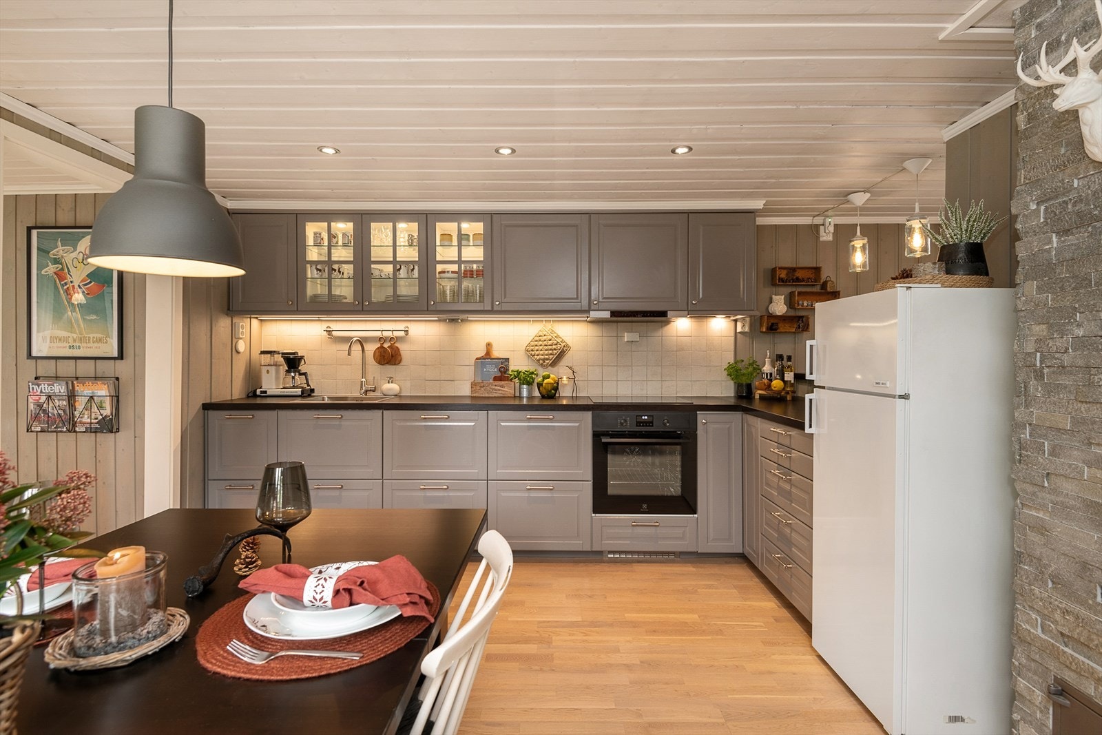 Innredningen er malt i en delikat og tidløs gråtone. Overskap og i all hovesak skuffer for god oppbevaring. Integrert komfyr og oppvaskmaskin. Plass til kjøleskap. Galleribilde