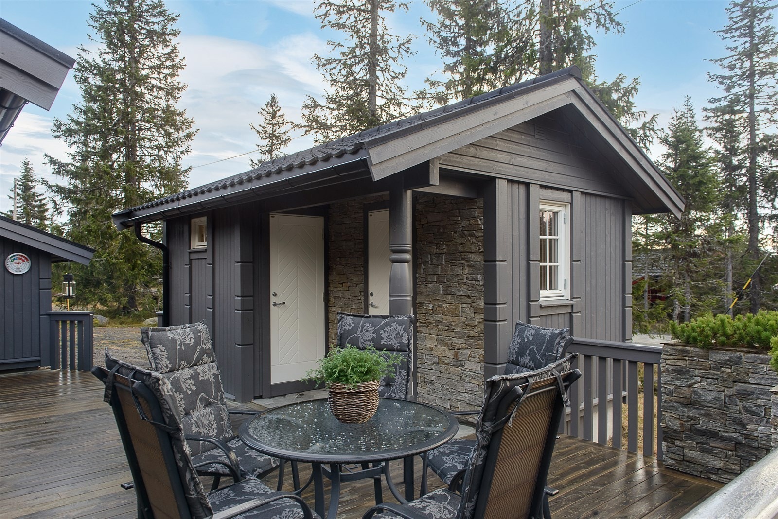 Det er fine innslag av tørrmurer på fasadene og en pent omrammet terrasse på hytta. Eiendommen ligger på Vassbakken, med enkel adkomst fra Rømåsvegen. Galleribilde