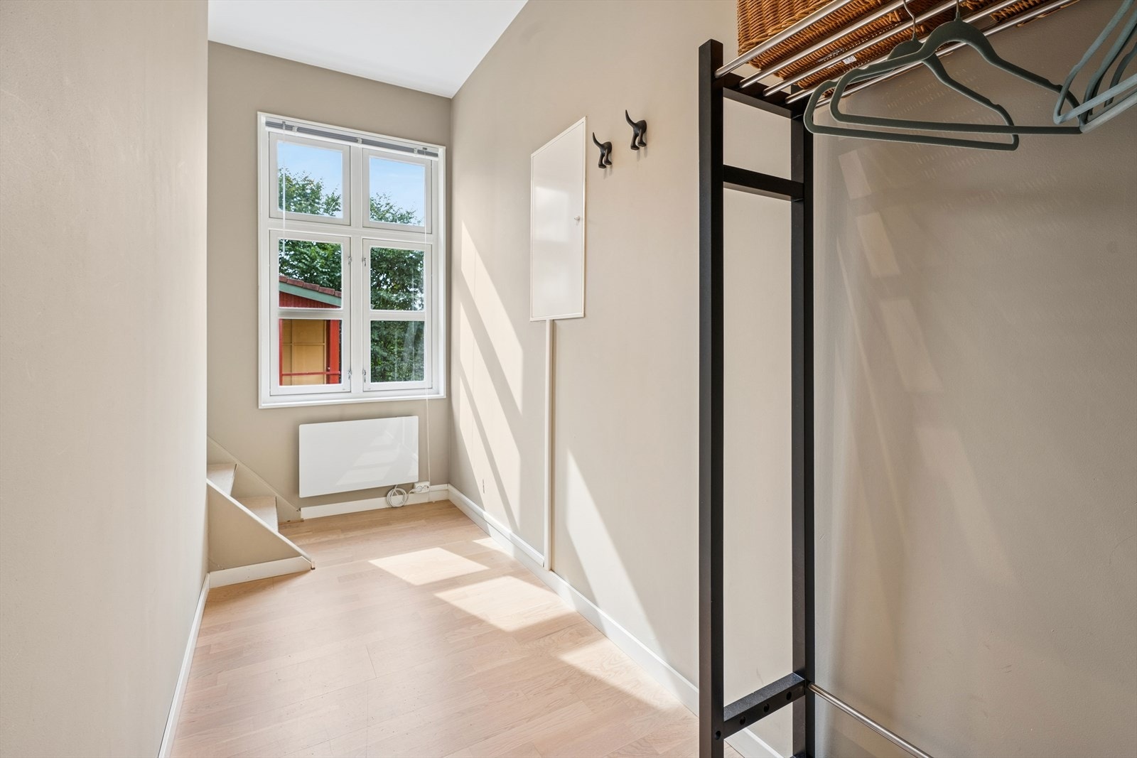 Leiligheten har en lys og romslig entré med god plass til både yttertøy og sko, og et praktisk trapperom som leder opp til loftsetasjen. Her får du et stort, tradisjonelt vindu, noe som skaper en lys og luftig atmosfære allerede ved inngangspartiet. Galleribilde
