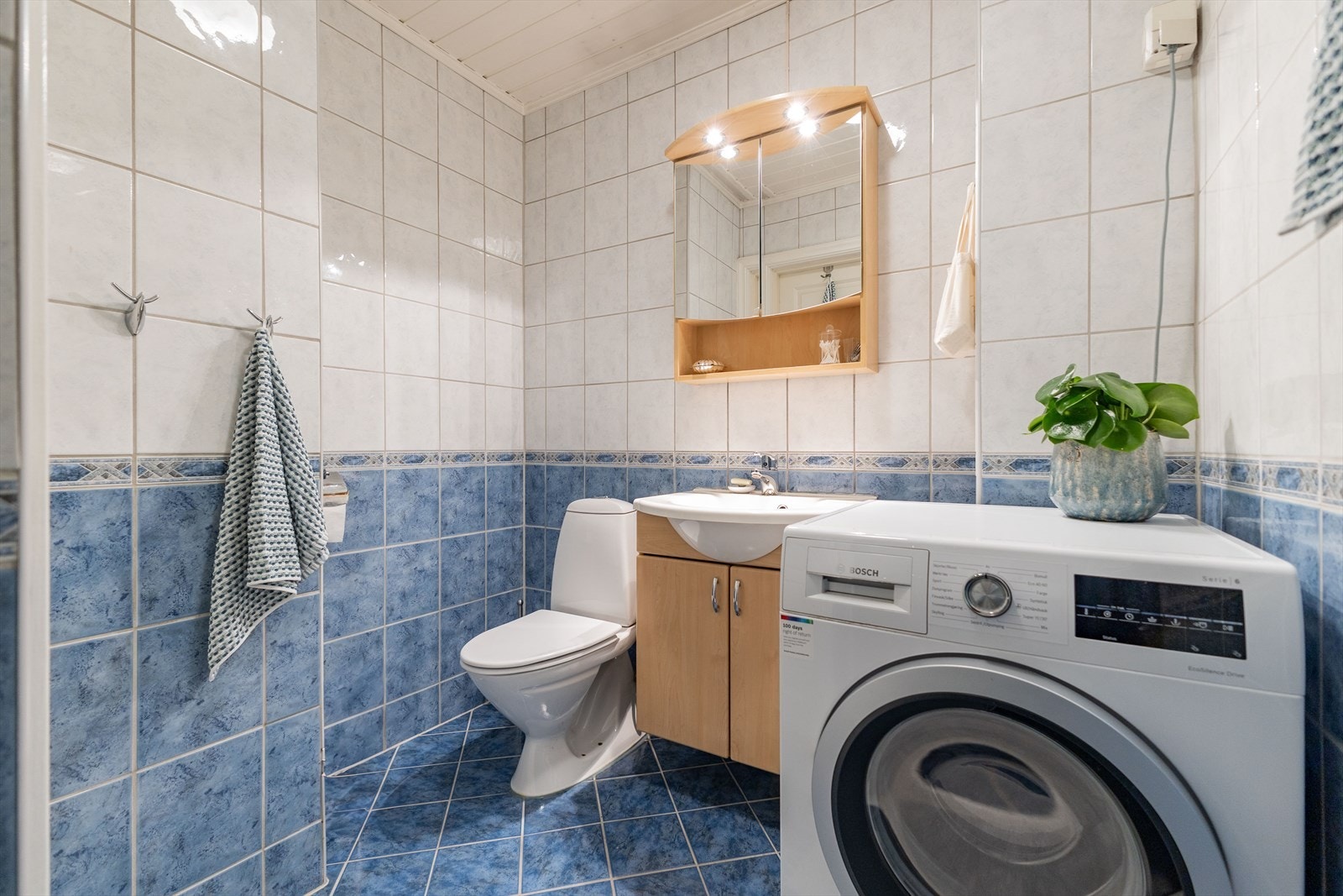 Baderommet har fliser på gulv og vegger, samt himling med panel. Galleribilde