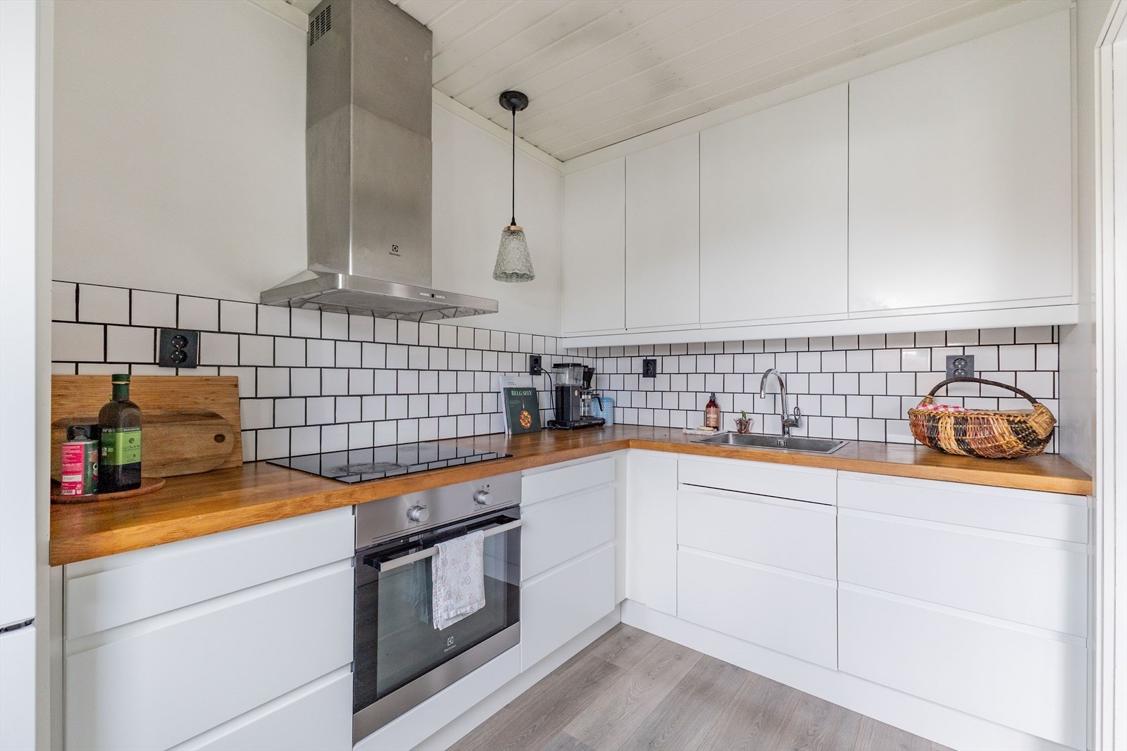 Det er benkeplate av tre med stål vask og over benk er det flislagt. Det er sorte og flate stikkontakter på kjøkkenet, som både gir et funksjonelt og stilfullt uttrykk. Galleribilde