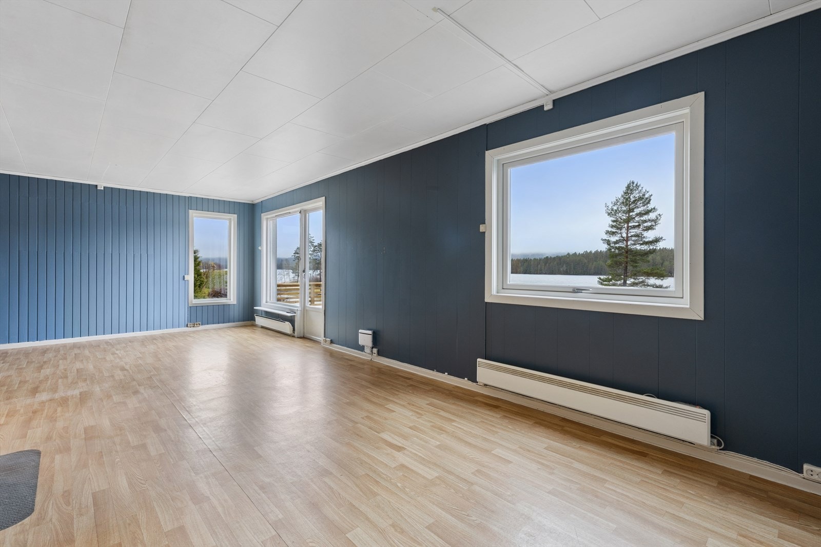 De mange vinduene i stuen som skaper en atmosfære av lys, varme og åpenhet Galleribilde