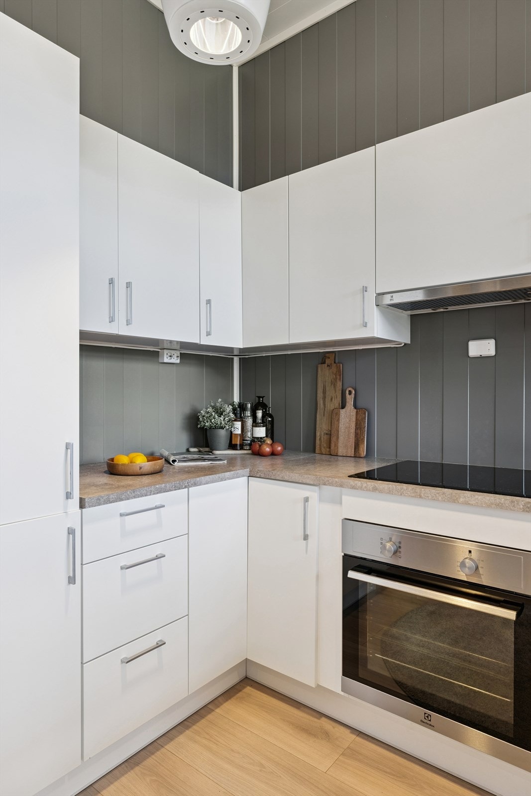 Kjøkkeninnredning med glatte fronter, laminat benkeplate og integrert stekeovn. Galleribilde