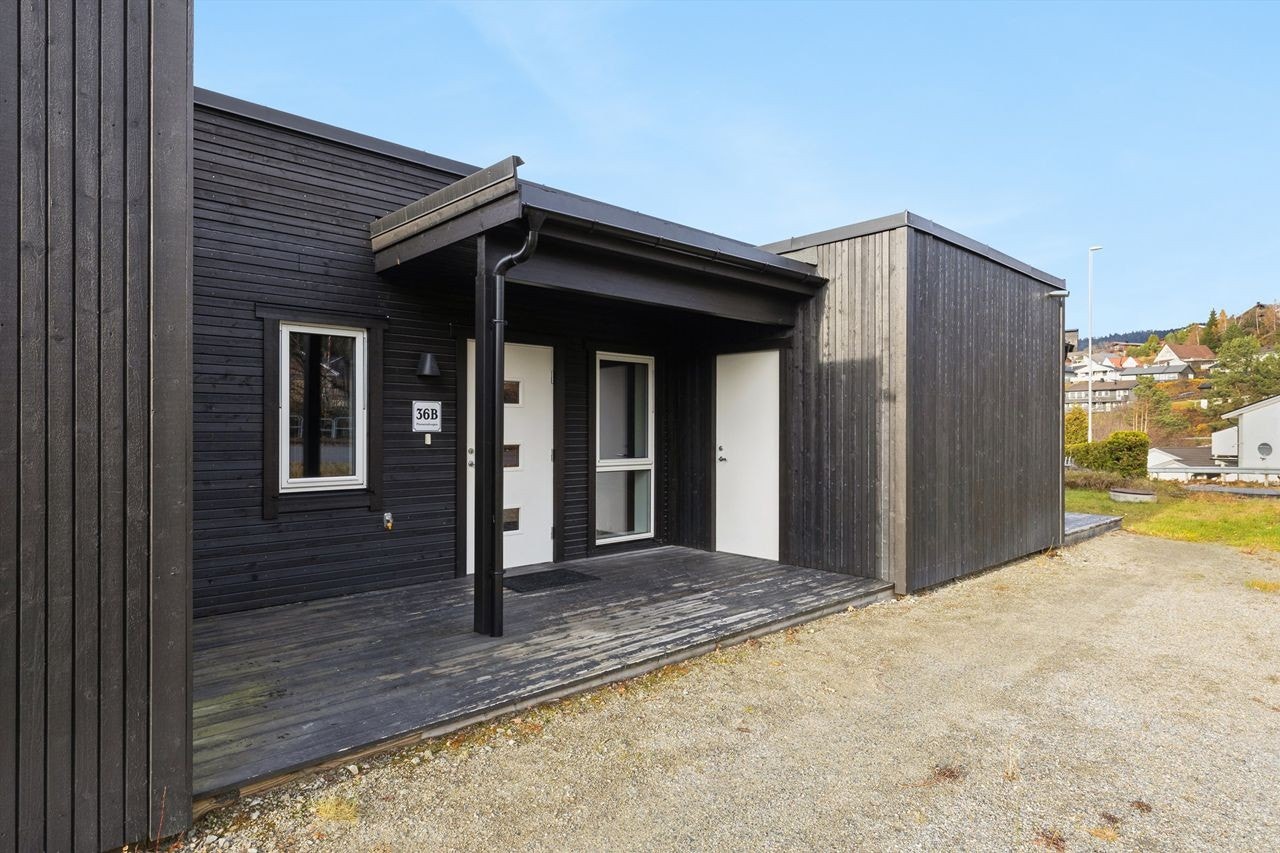 Overbygget inngangsparti som gir ly for vær og vind. Galleribilde