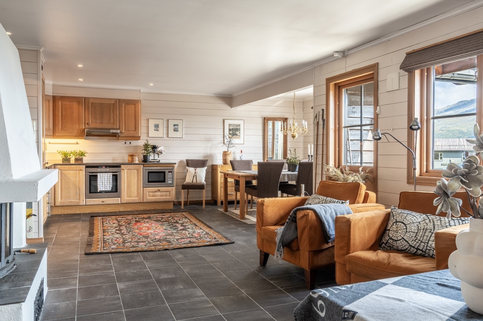 Romslig stue med store vindusflater, hyggelig spiseplass og utgang til veranda. Galleribilde