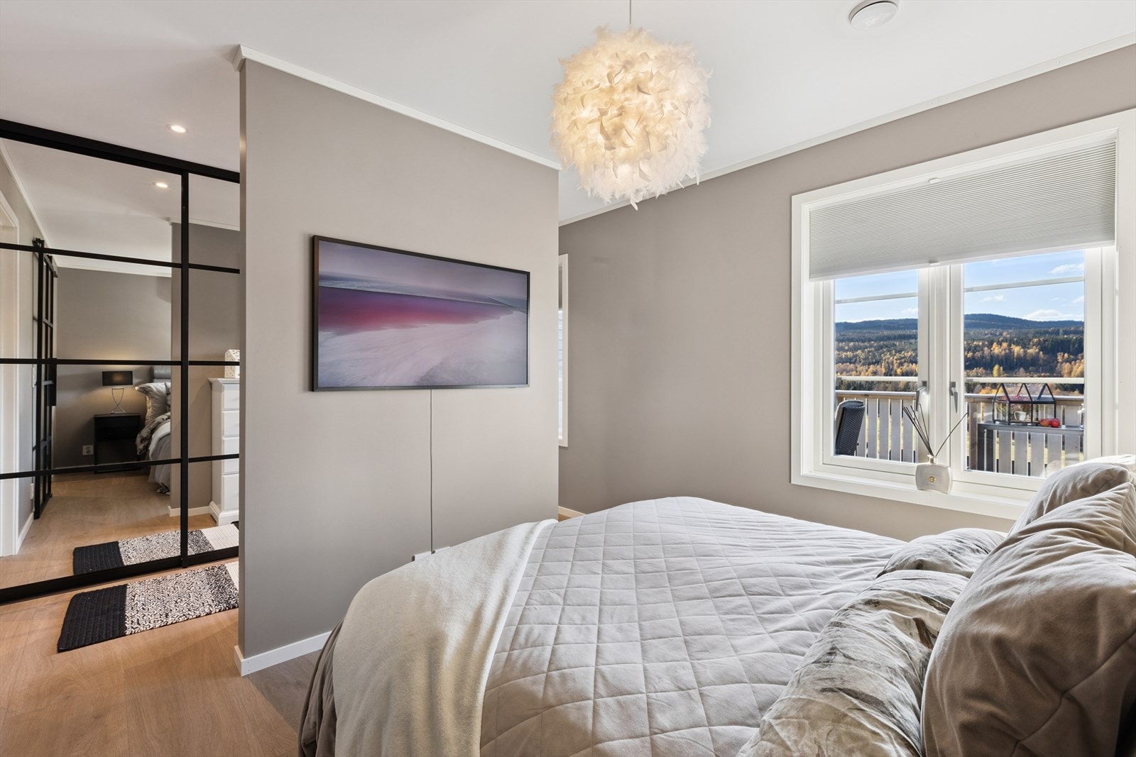 Her finner du en egen garderobeløsning som gir praktisk oppbevaring, samt en romdeler med TV-uttak som skaper en lun og funksjonell sone i rommet. Galleribilde