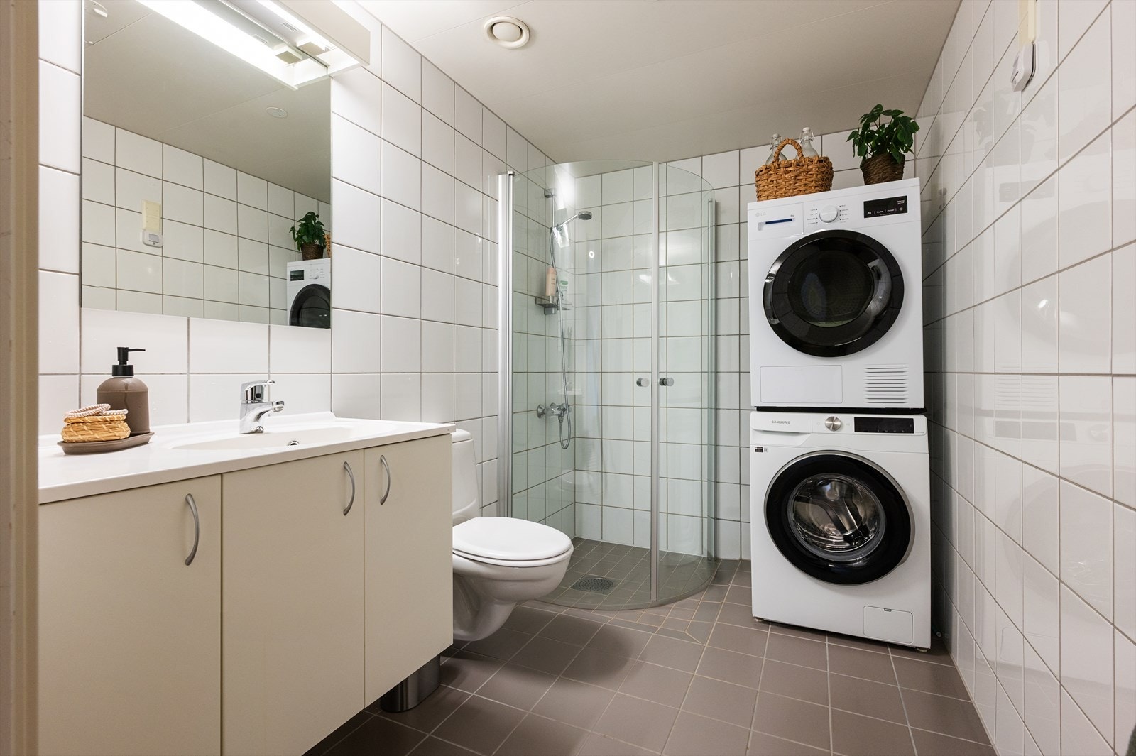 Romslig baderom med dusjhjørne med innfellbare dusjvegger og opplegg for vaskesøyle. Galleribilde