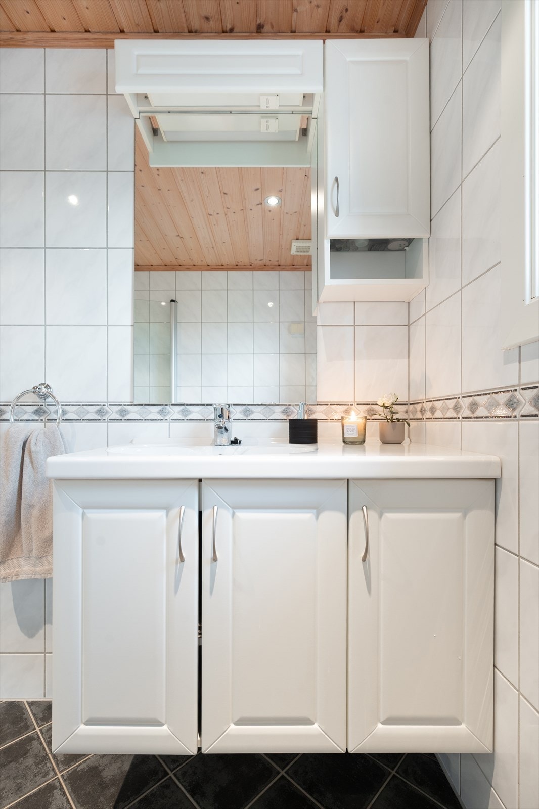 Badet er fra 2007 med fliser på gulv og vegger, dusjløsning med glassdører og et lite vindu som gir naturlig lufting. Rommet fremstår pent brukt. Galleribilde