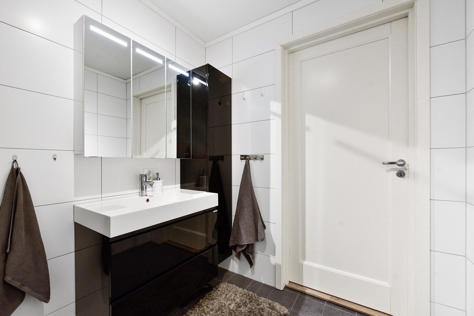 Baderomsinnredning med heldekkende servant, speilskap og ekstra lagringsplass i høyskap Galleribilde