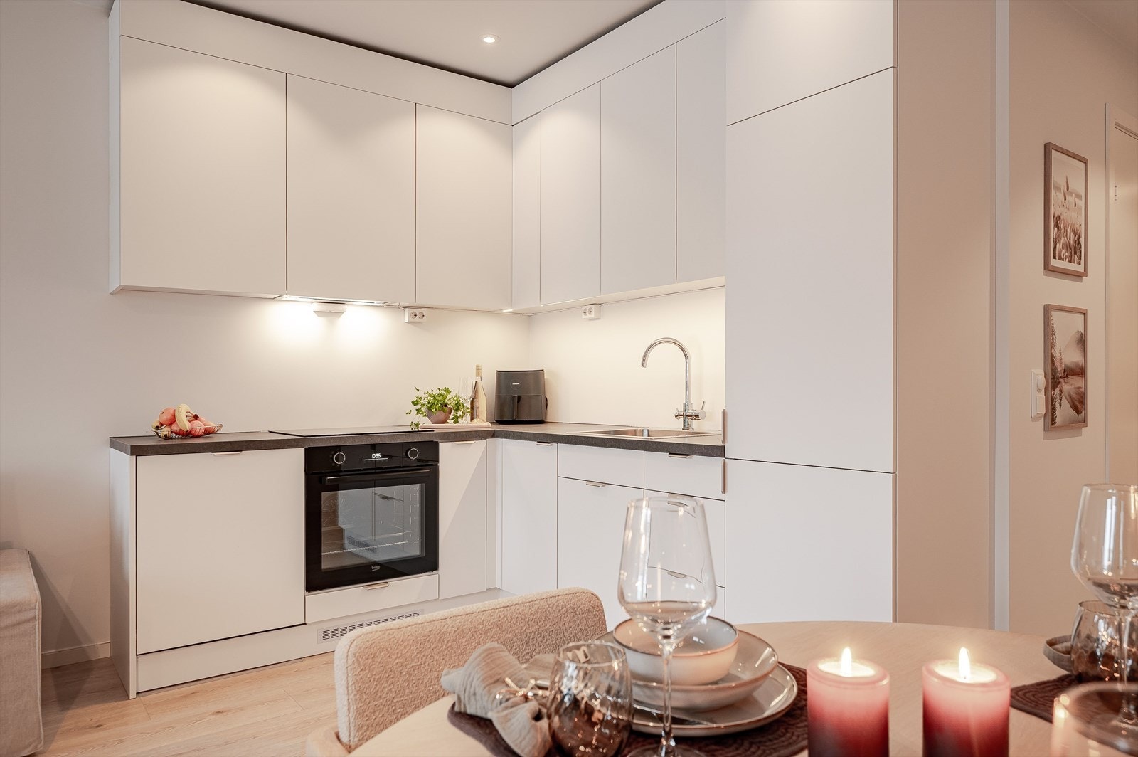 Integrerte hvitevarer og praktisk benkeplass gjør kjøkkenet effektivt og brukervennlig. Galleribilde