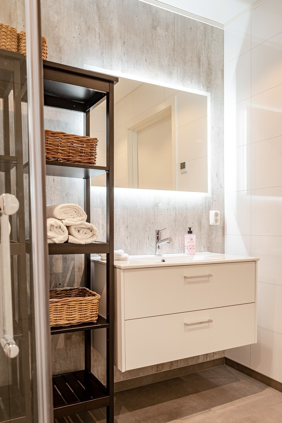 Speil med belysning og moderne servant gir funksjonell baderomsinnredning. Galleribilde