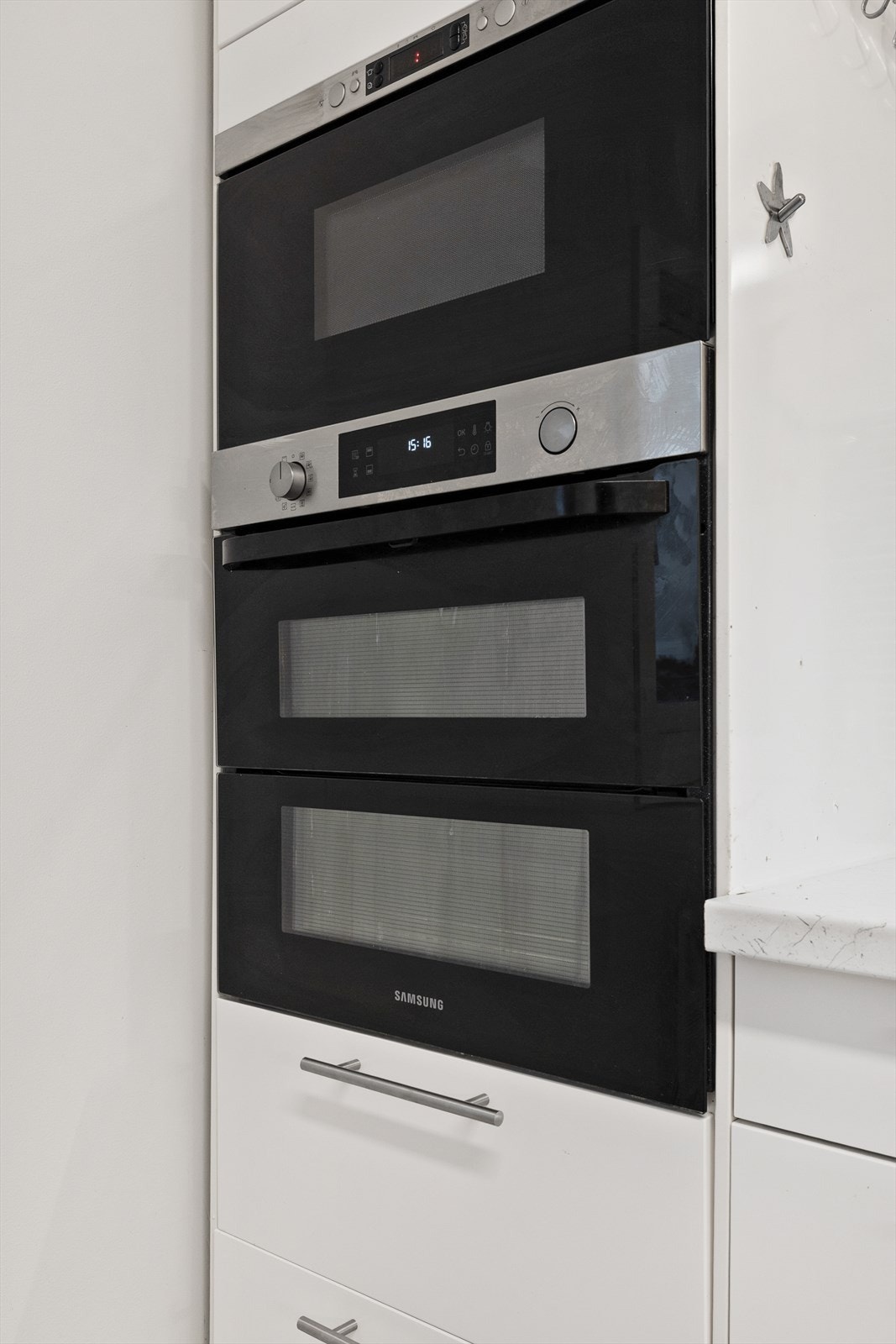 Kjøkken med integrerte hvitevarer som stekeovn/platetopp/mikrobølgeovn/oppvaskmaskin som følger leiligheten. Galleribilde