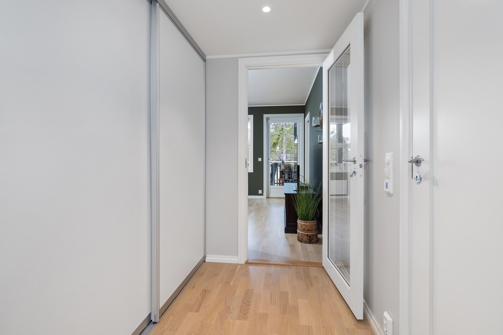 Velkommen inn i en lys entré med downlights og dør med glassfelt mot stuen. Galleribilde