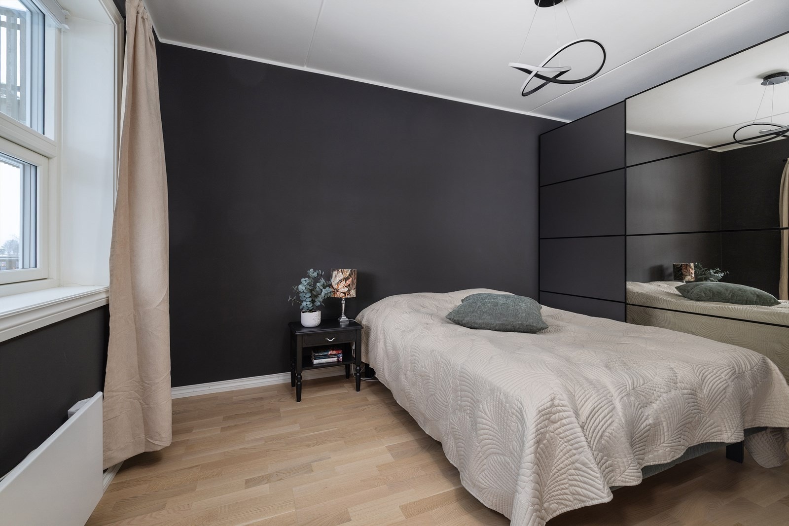 En stor skyvedørsgarderobe med speilfronter gir rikelig med lagringsplass. Galleribilde