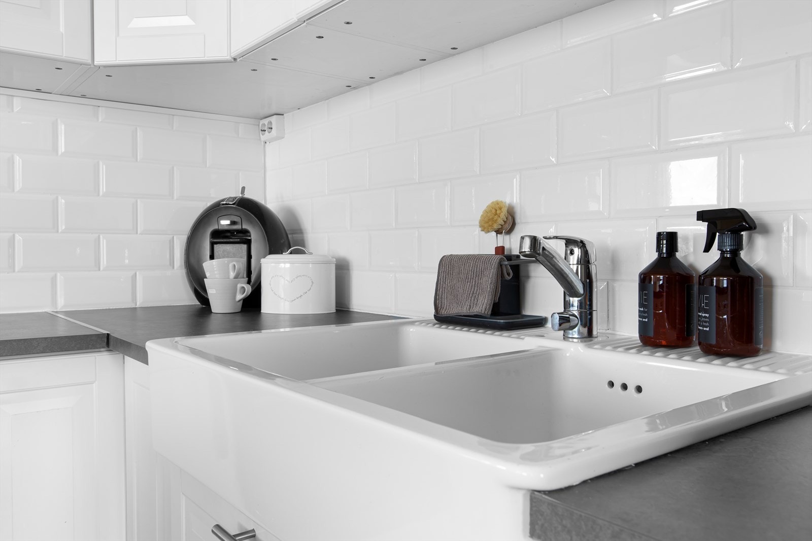 Hvite fliser over benken og hvit dobbel servant. Galleribilde