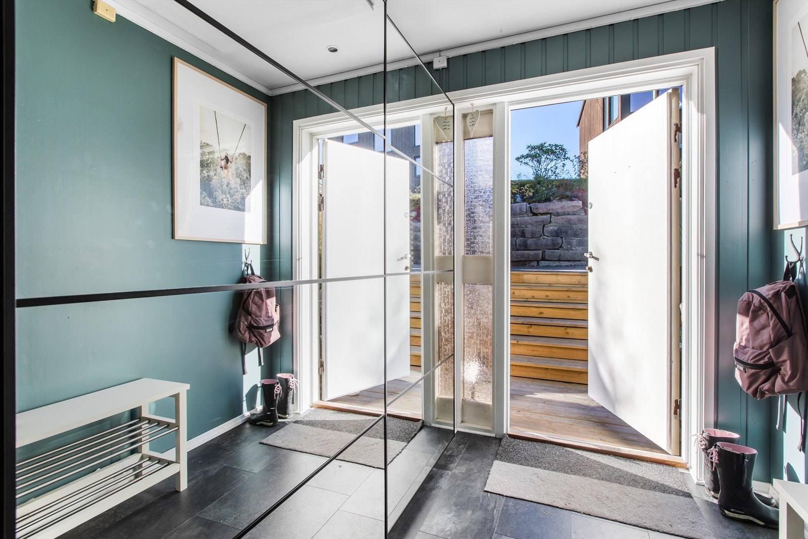 Velkommen inn. Gangen har laminat flis og malte panelvegger. Innholdsrik garderobe med speilfronter. Galleribilde