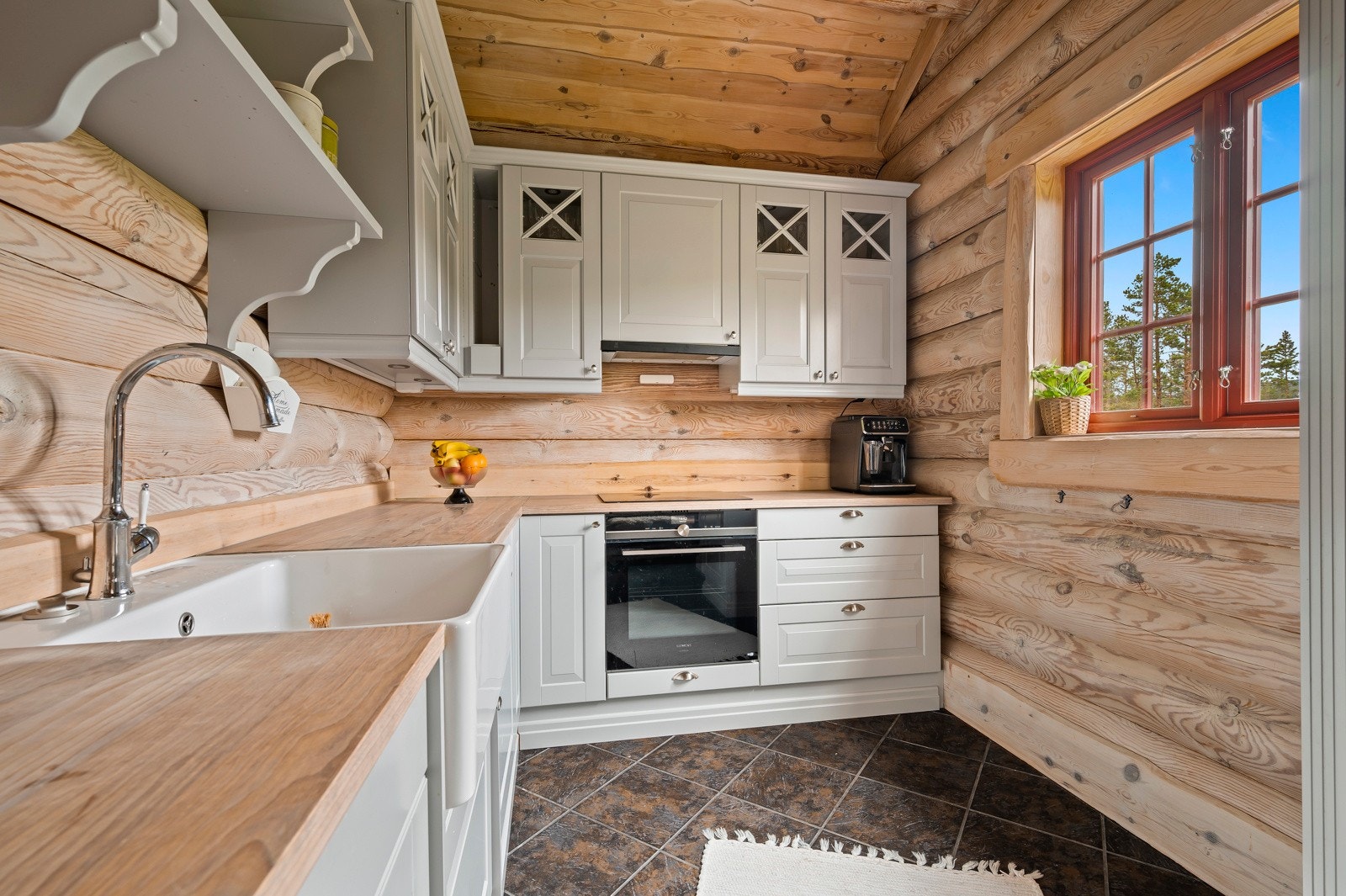 Kjøkkeninnredningen har profilerte fronter og utført i en praktisk L-form med heltre benkeplate. Galleribilde