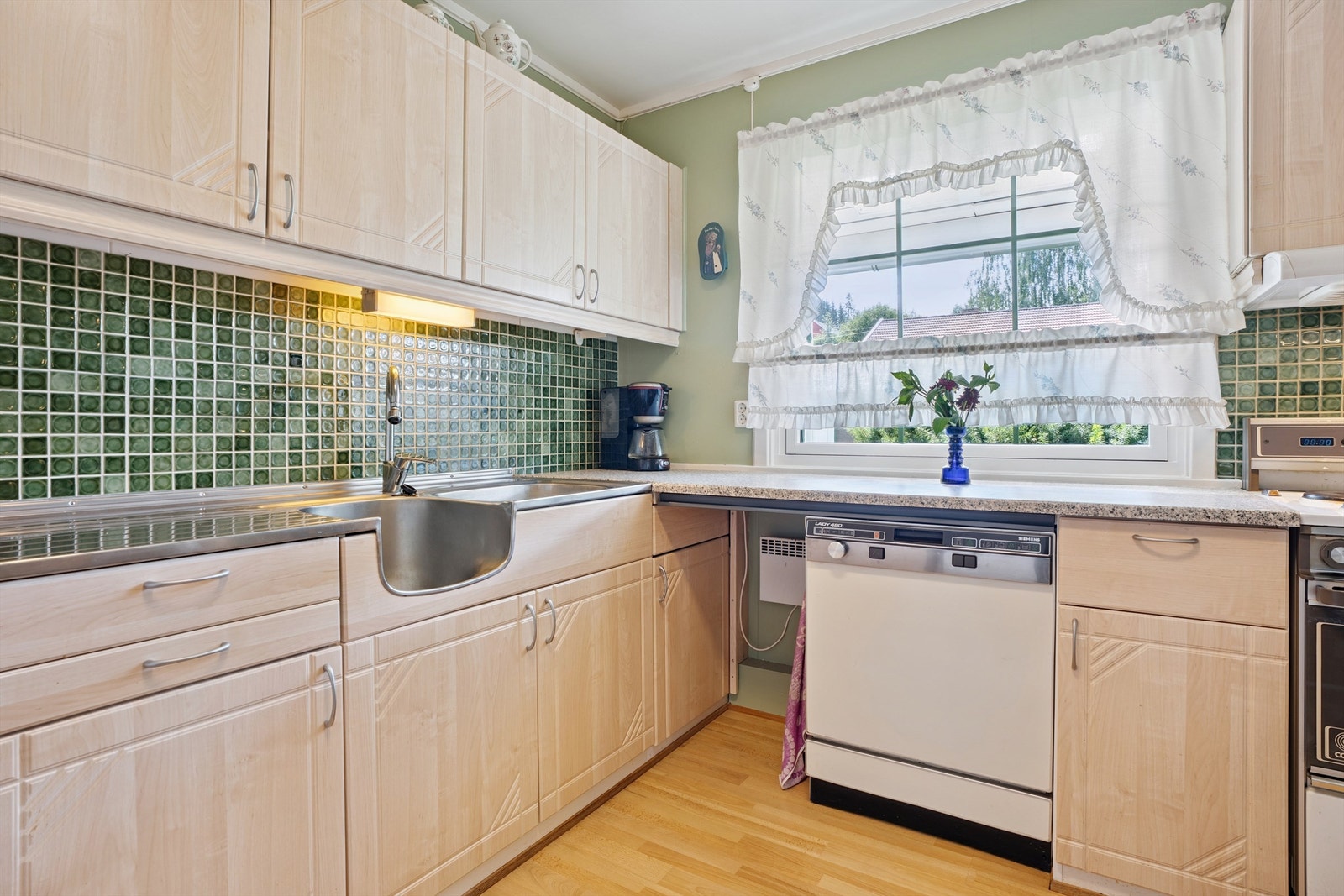 Kjøkken med flislagt veggflate over arbeidsbenken Galleribilde