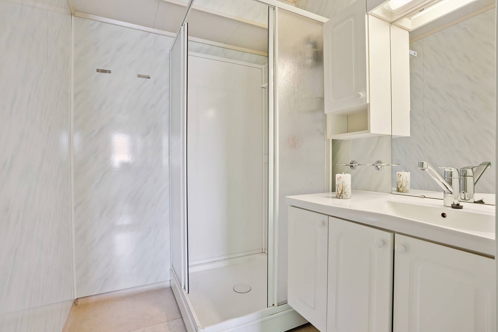 Bad i første etasje utstyrt med servantskap og dusjkabinett Galleribilde