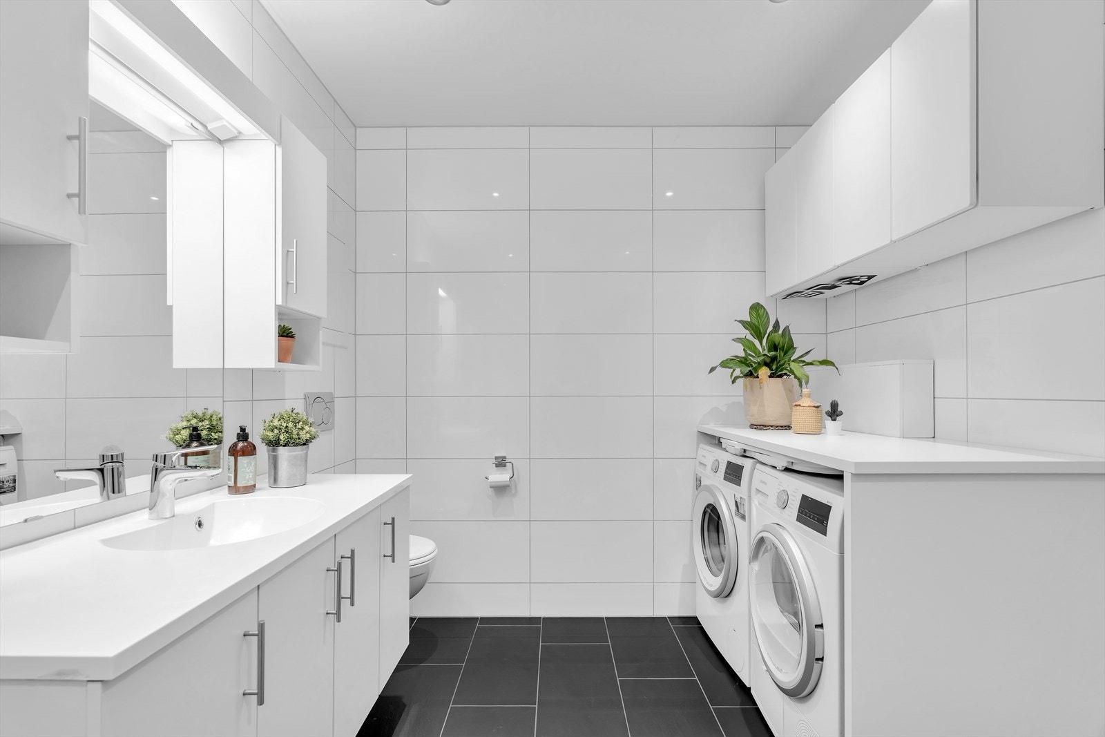 Leiligheten har et pent og moderne bad med fliser på både gulv og vegger, samt varmekabler som gir en behagelig varme. Galleribilde