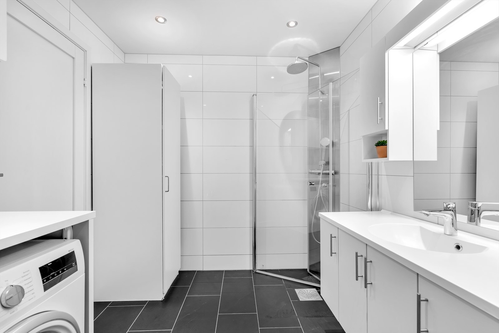 Badet er godt utstyrt og inneholder et dusjkabinett, som ble nylig oppgradert i 2023, et vegghengt toalett og en innredning med skap som gir god oppbevaringsplass. Galleribilde