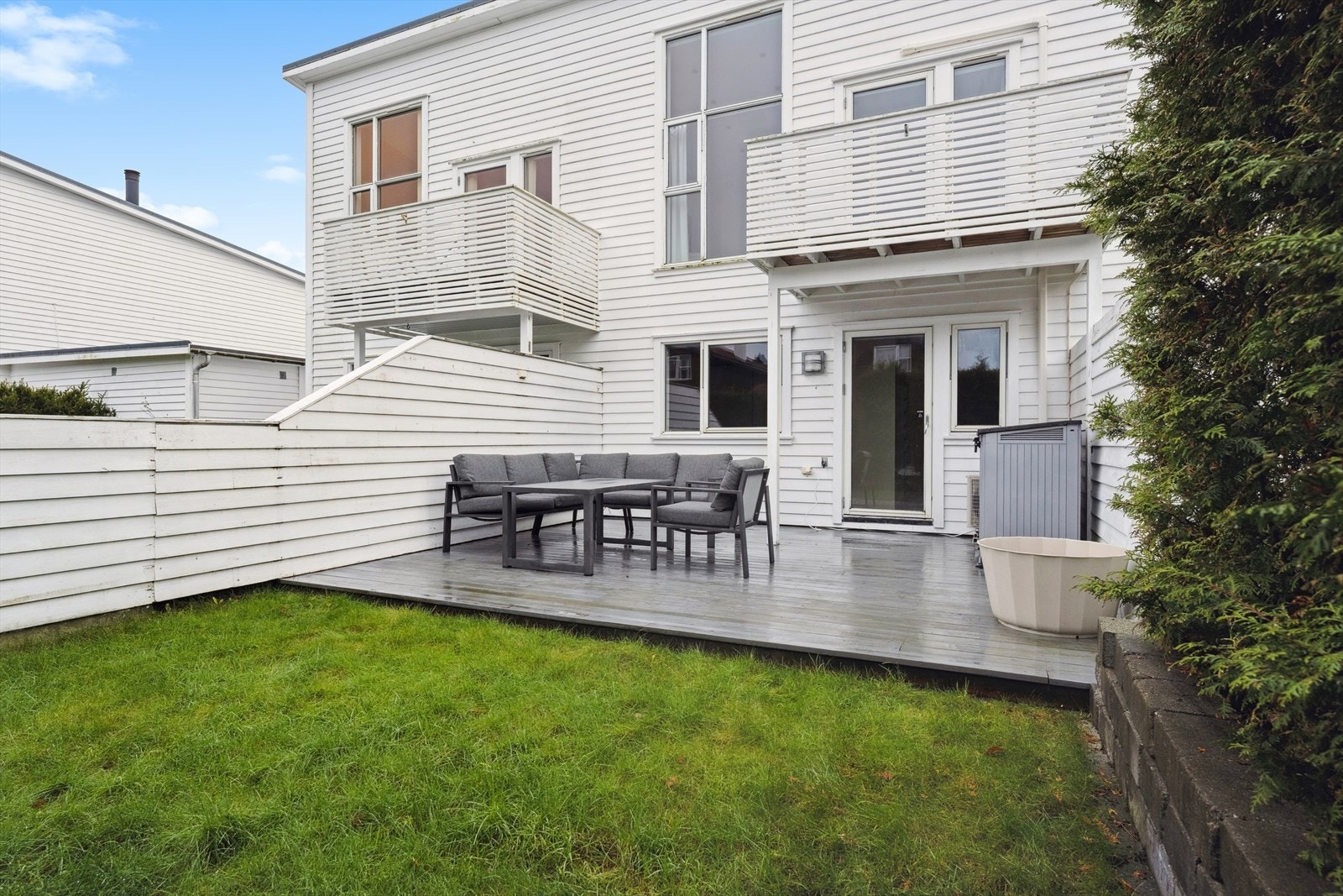 Terrassebord og gressplen gir en innbydende uteplass med god plass til møblering. Galleribilde