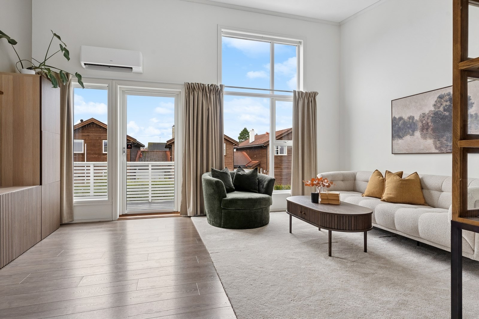 Stuen har en åpen og luftig følelse med høyt tak og store vindusflater som gir utsikt. Galleribilde