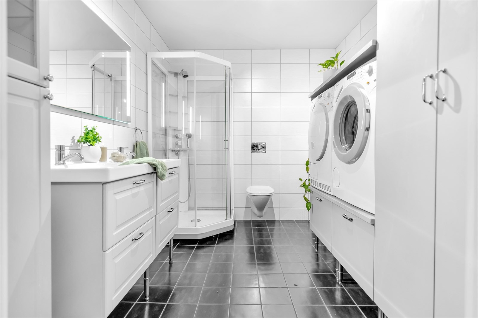 Det er også opplegg for vaskemaskin og tørketrommel i praktisk ståhøyde, noe som gjør hverdagen enklere. Mekanisk avtrekk sørger for god ventilasjon, og varmekabler i gulvet gir ekstra komfort. Galleribilde