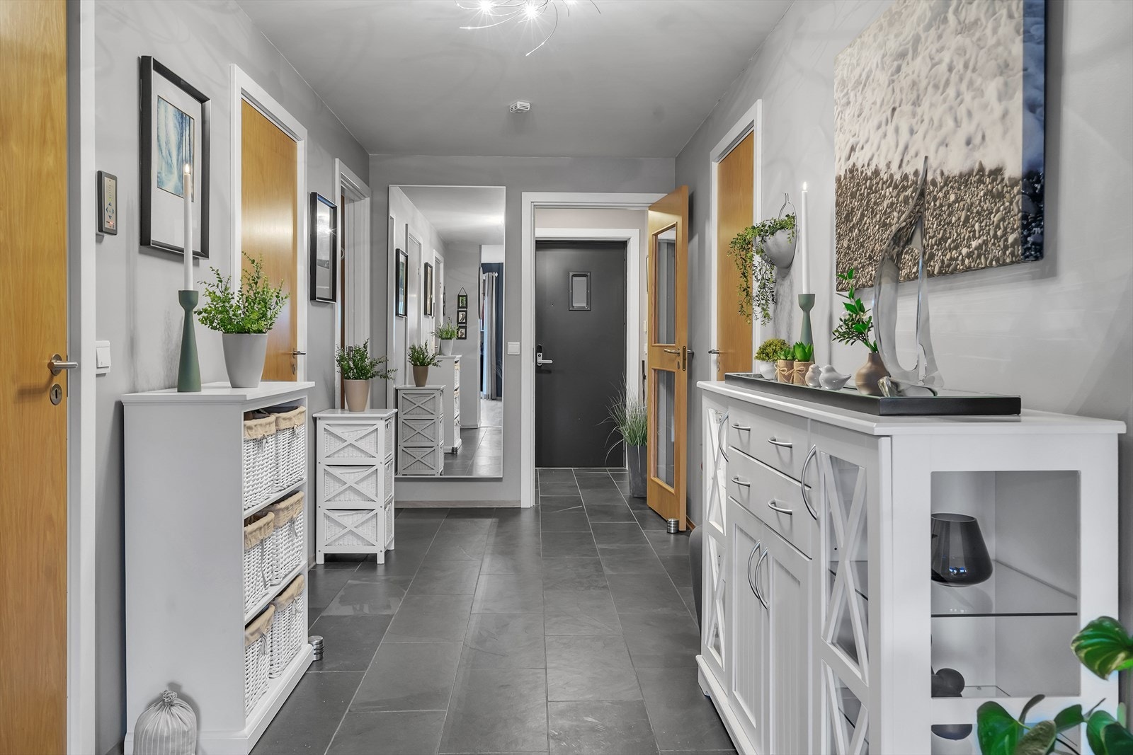 Entré og romslig gang som ønsker deg velkommen med et moderne og innbydende førsteinntrykk. Gulvet er elegant flislagt og har behagelig gulvvarme som sikrer en lun og komfortabel start hver dag. Galleribilde