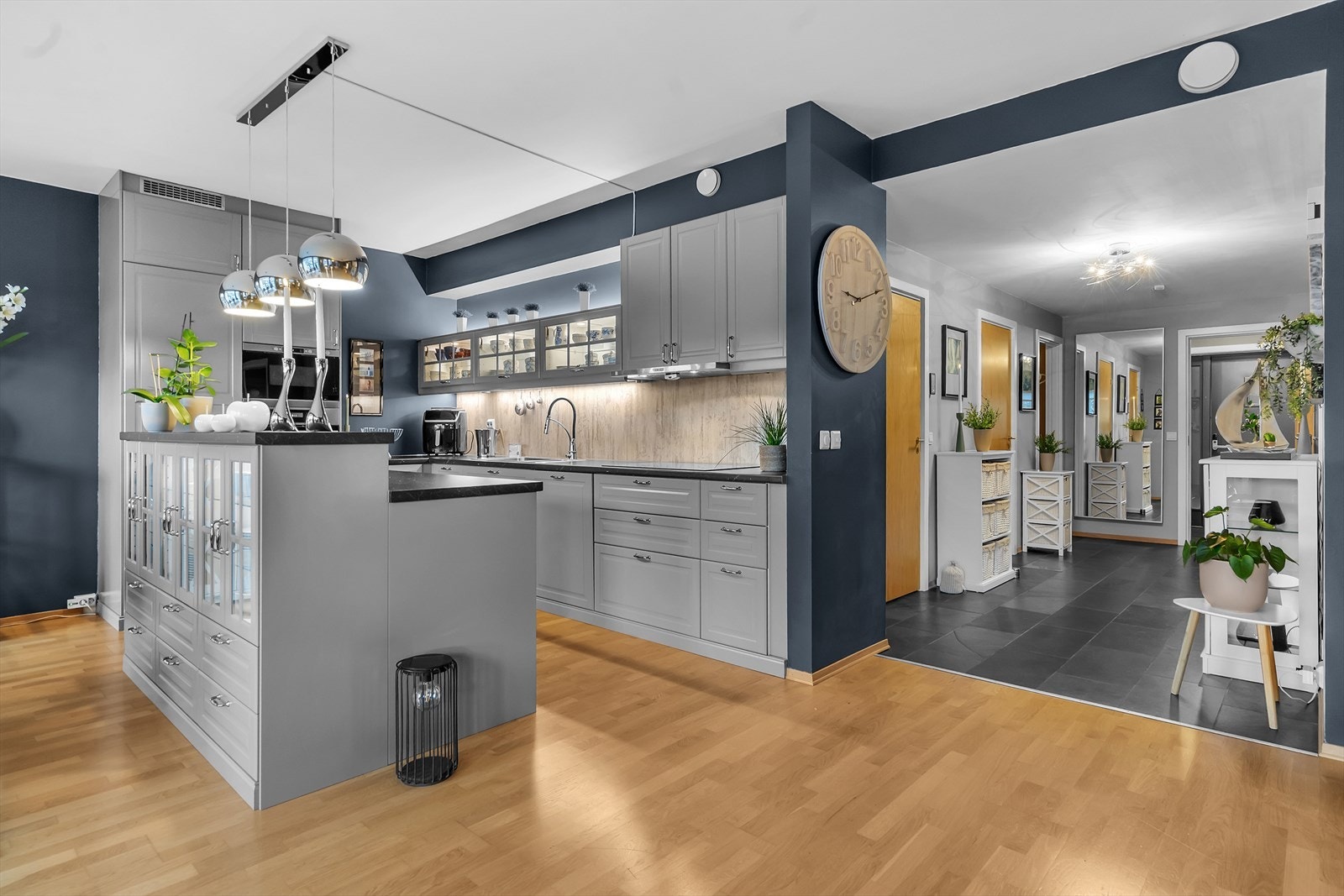 Den åpne og luftige planløsningen mellom stue og kjøkken er pent adskilt med en praktisk kjøkkenøy, som forener rommene på en funksjonell måte. Galleribilde