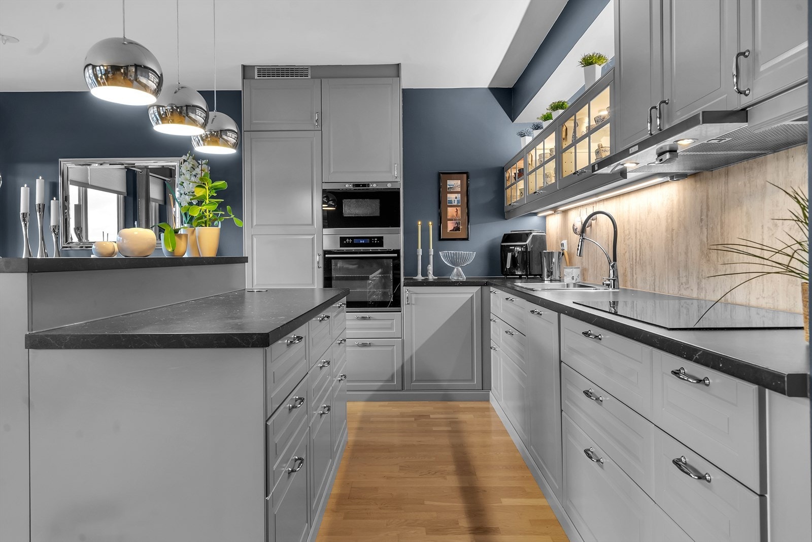 De integrerte hvitevarene inkluderer platetopp, stekeovn og mikrobølgeovn plassert i ergonomisk ståhøyde, samt kjøle-/fryseskap og oppvaskmaskin - alt designet for å gi en sømløs og helhetlig stil. Galleribilde