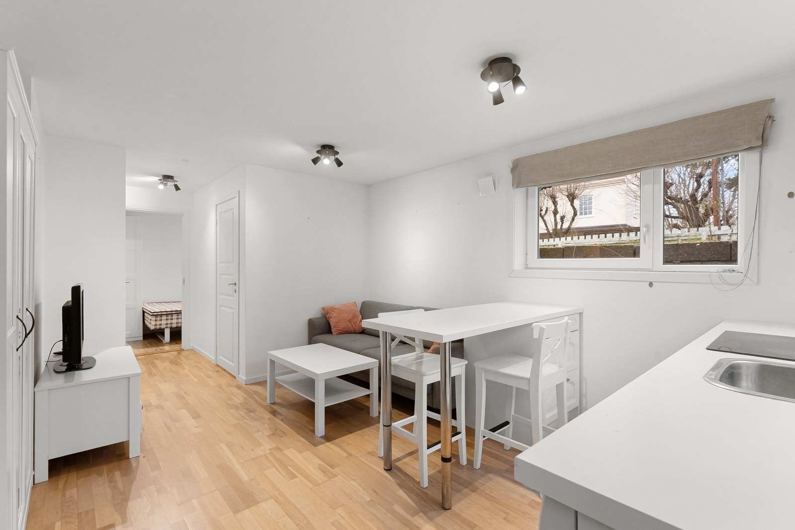 Overflatene er malt i en lys hvit-tone og gulvet er belagt med trestavs parkett. Galleribilde