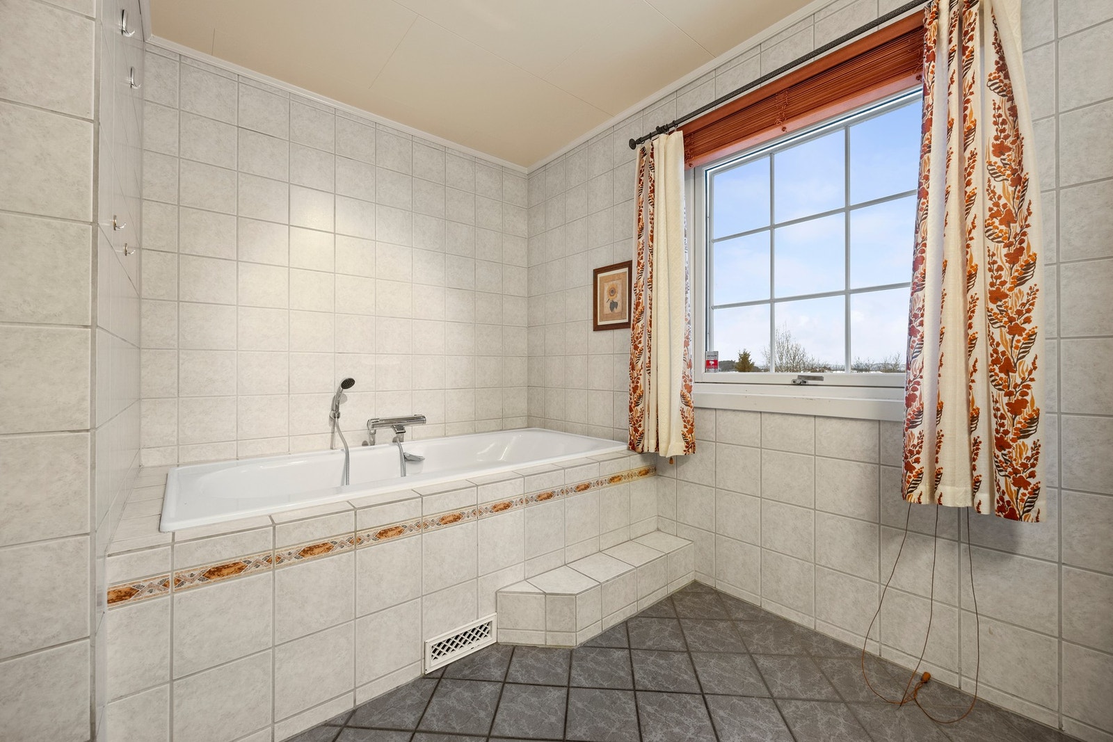 Badet er utstyrt med innebygd badekar, servantskap, toalett og dusjkabinett Galleribilde