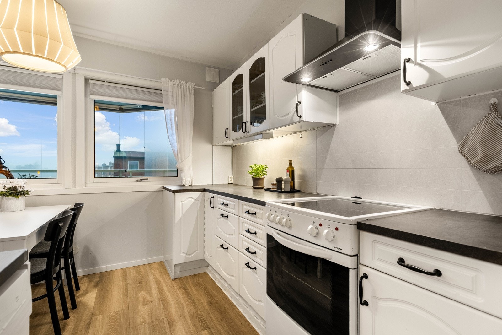 Lyst og praktisk kjøkken med god benkeplass og spiseplass ved vinduet. Galleribilde