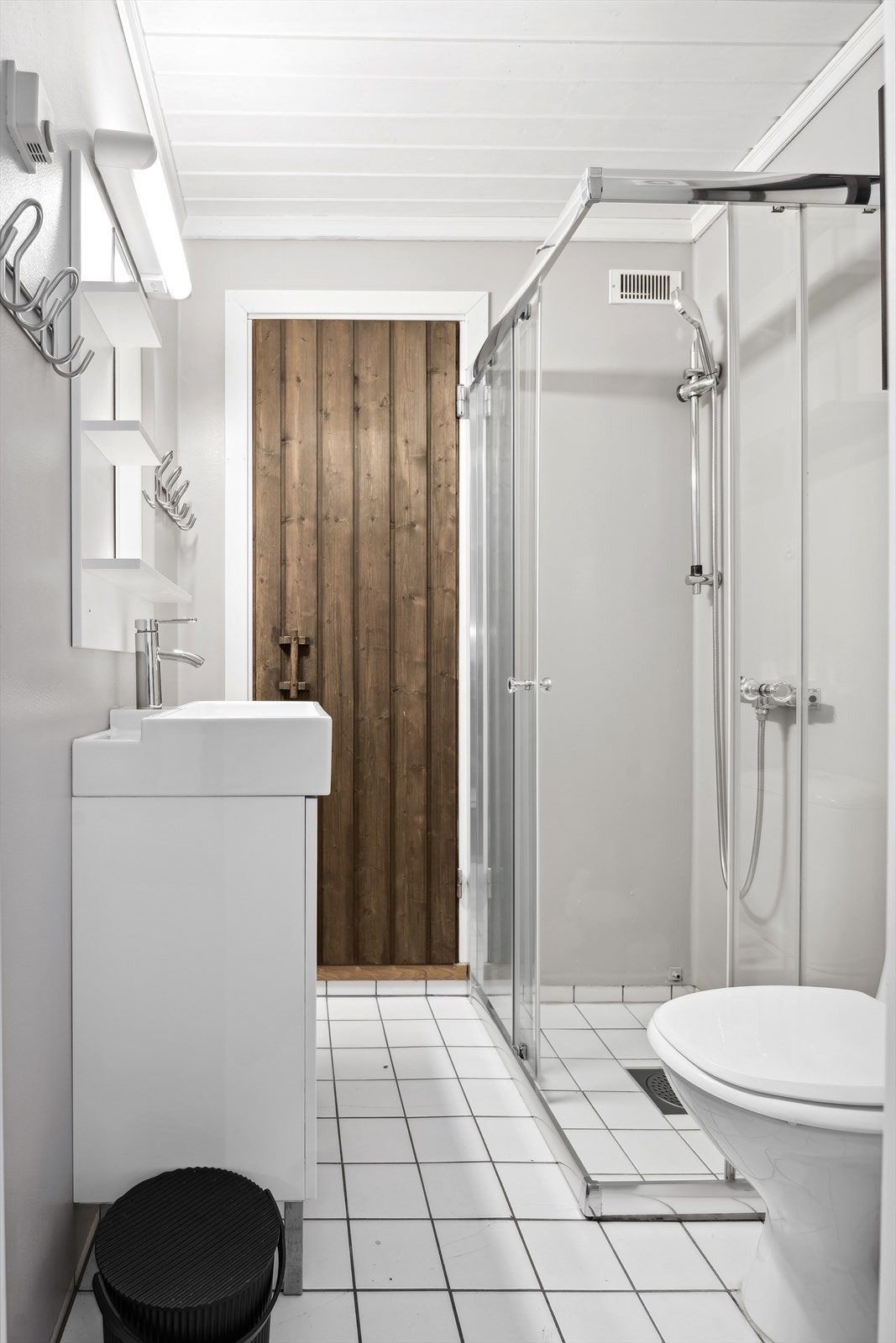 Baderom med dusjhjørne, servant med underskap, toalett og badstue Galleribilde