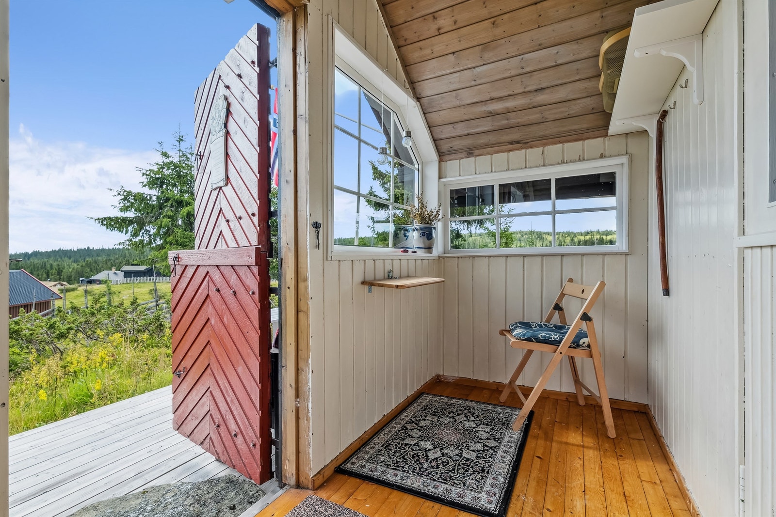 Her kommer du inn i et lysmalt vindfang med tregulv og flere vinduer som slipper dagslyset inn i rommet. Galleribilde