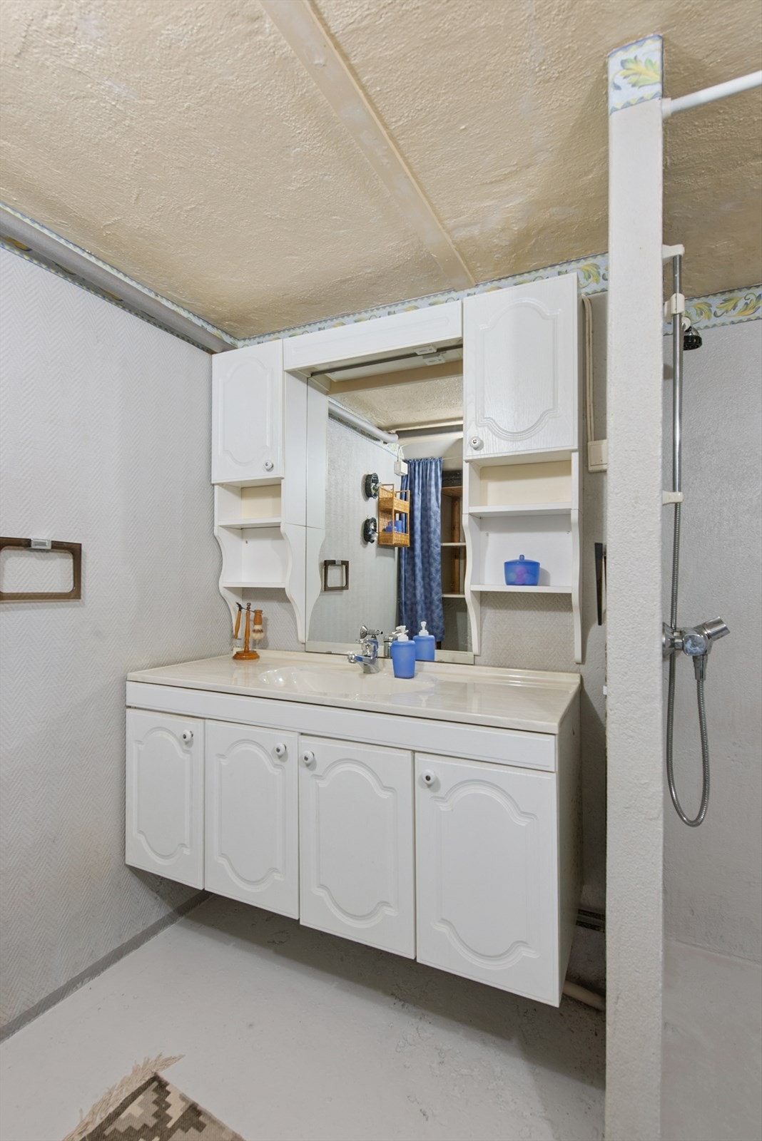 Kjelleren har et kombinert bad og vaskerom med malte/tapetserte vegger og malt betonggulv. Galleribilde