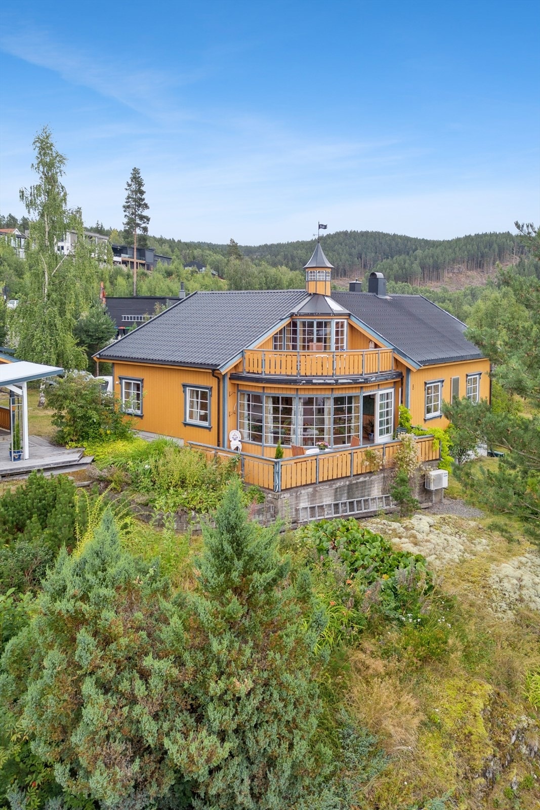 Sjarmerende bolig med arkitektoniske detaljer og takterrasse, omgitt av grønne åser og nabolag. Galleribilde