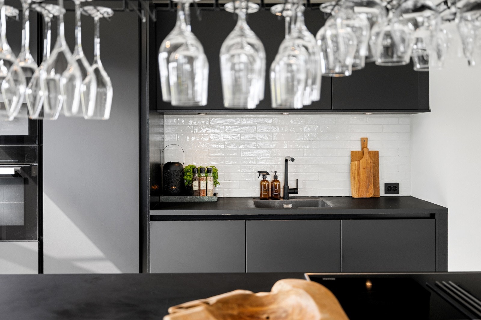 Stiling kjøkkenhylle over kjøkkenøyen som elegant deler rommet inn i soner. Galleribilde