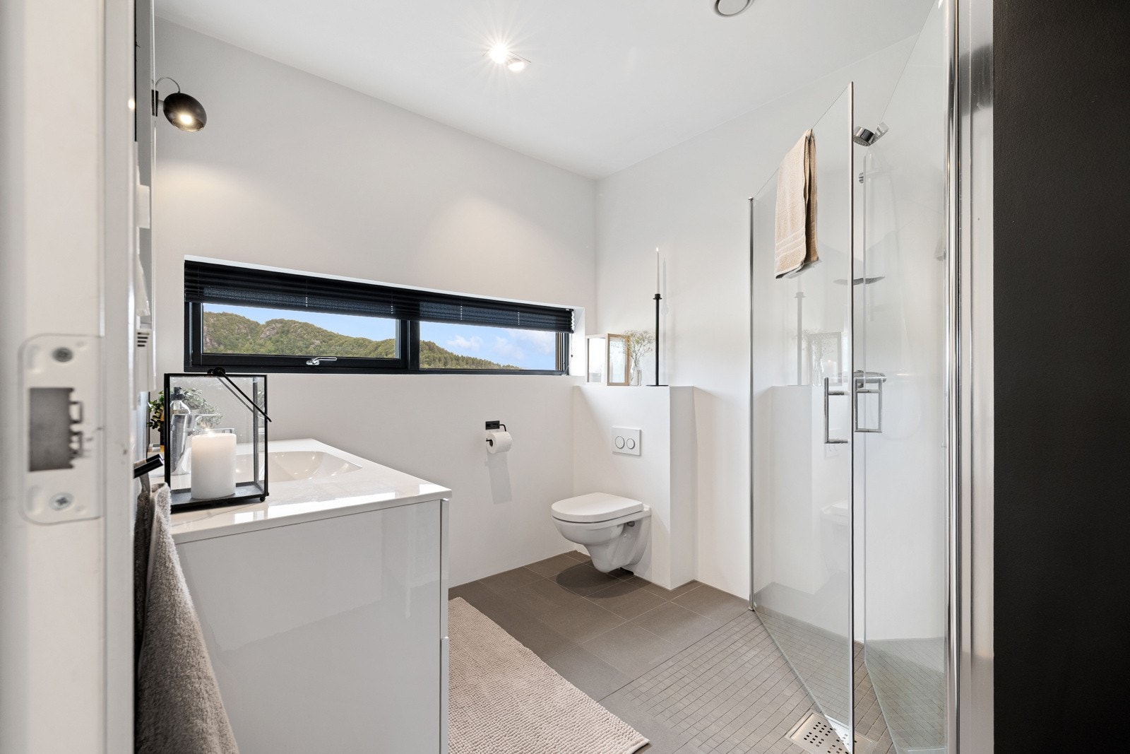 Badet i andre etasje har fliser på gulvet og er malt med Jotun våtromssystem på veggene. Her er dusj, veggheng toalett - Galleribilde