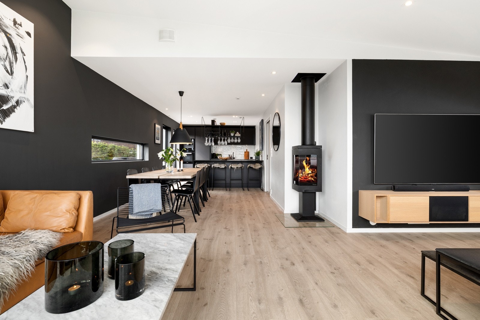 Peis fra Norpeis med glassdør - fint at flammene kan nytes både fra spisestuen og fra stuen. Det er fine fargvalg i huset i klassiske farger som hvit, sort, grå og beige. Galleribilde