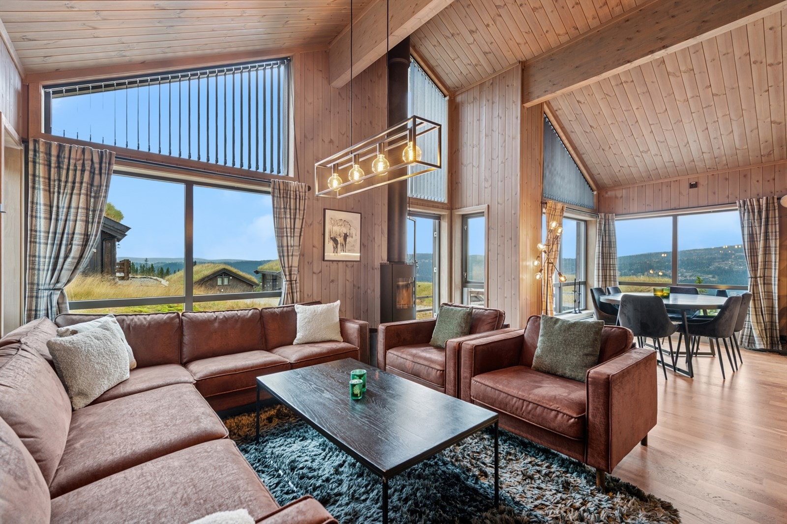 Romslig og lys stue med god takhøyde og store vindusflater. Galleribilde