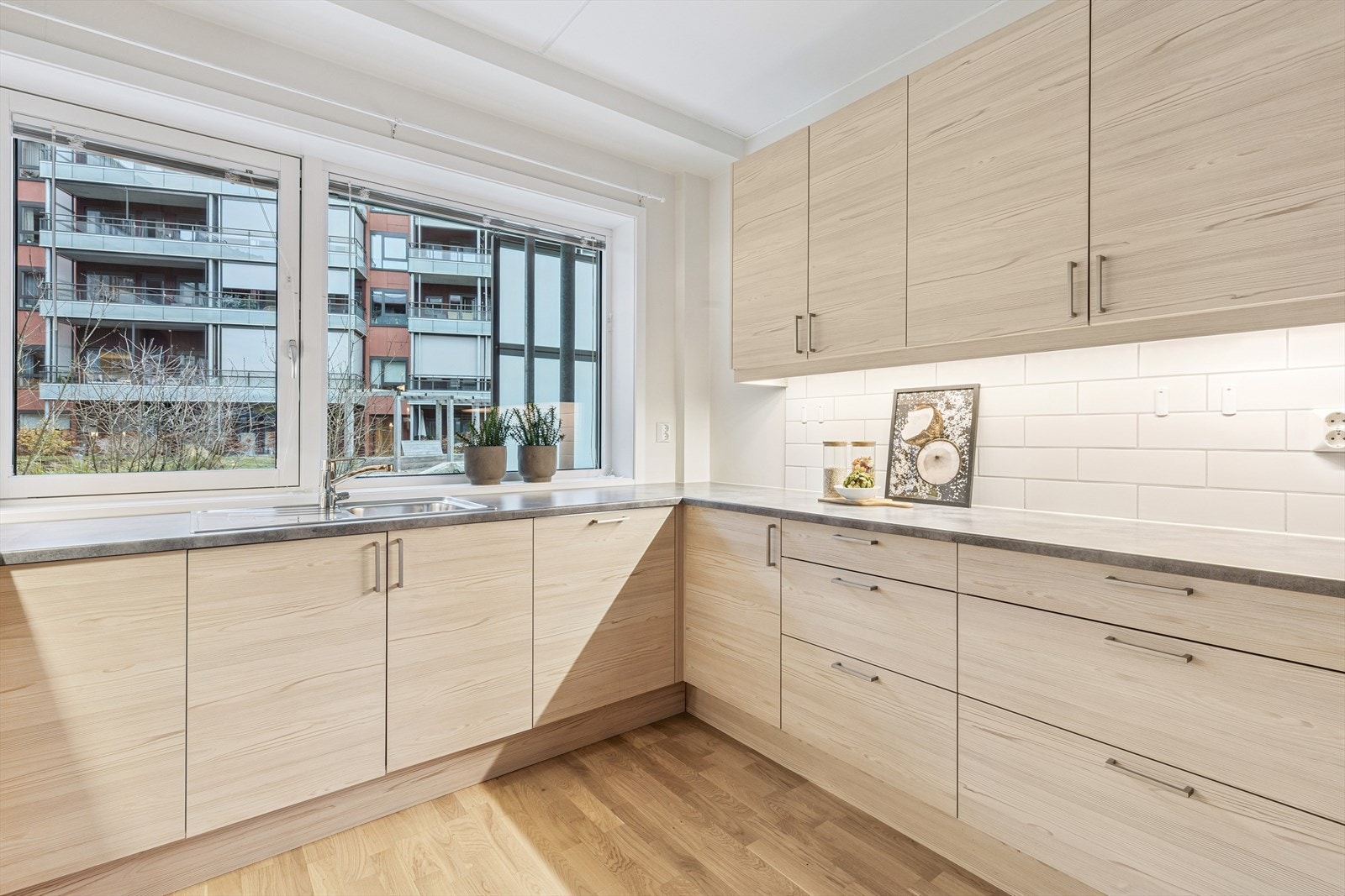 Her finner du moderne innredning med lyse fronter, god skapplass og integrerte hvitevarer. Galleribilde